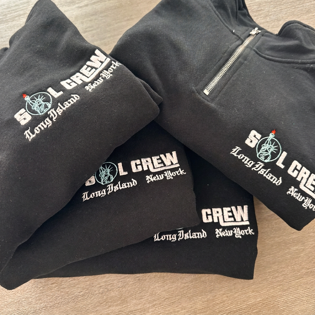 Matching SOL CREW logo embroidered on four quarter-zips for a team order