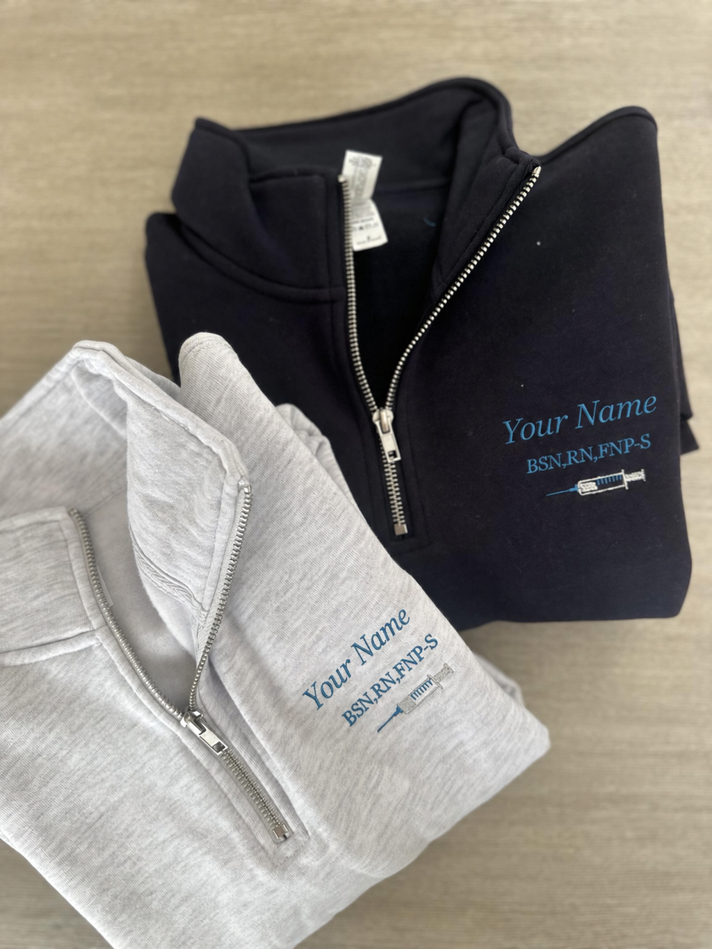 Nurse injector quarter-zip, syringe embroidery detail